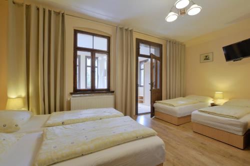 a bedroom with two beds and a flat screen tv at Dom Polana Karpacz in Karpacz