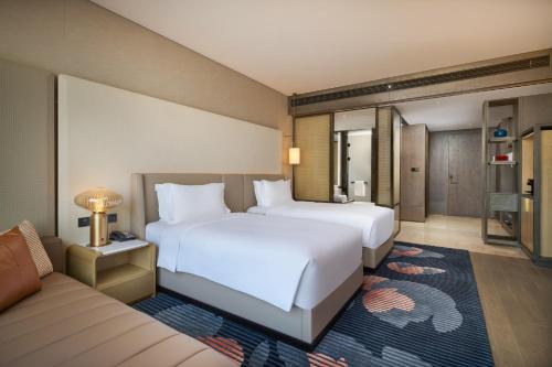 a hotel room with two beds and a couch at InterContinental Xi'an Hi-Tech Zone in Xi'an