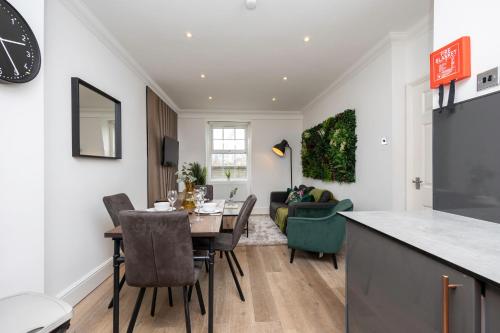 eine Küche und ein Wohnzimmer mit einem Tisch und Stühlen in der Unterkunft Stunning Two Bedroom Brighton Penthouse in Brighton & Hove