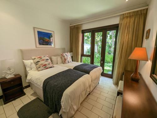 a bedroom with a large bed and a window at Waterfront Maison by Simply-Seychelles in Eden Island