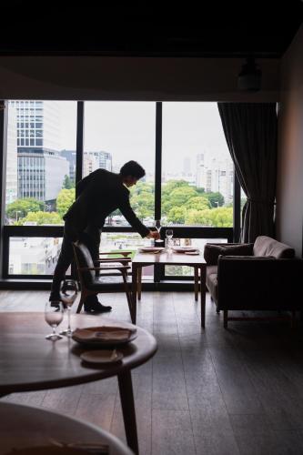 a man bending over a table in a living room at The Tower Hotel Nagoya in Nagoya
