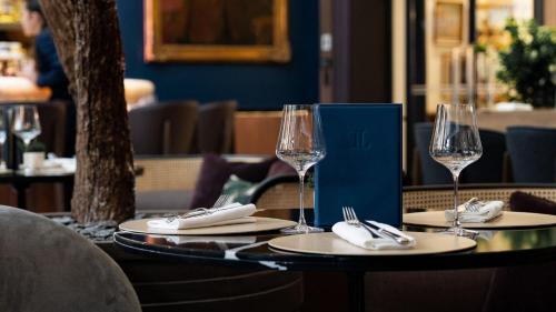 a table with two wine glasses and napkins at Hôtel Lancaster Paris Champs-Elysées in Paris