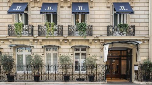 فندق لانكاستر باريس شانزليزيه في باريس: مبنى به نوافذ وشرفات عليها نباتات