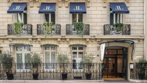 a building with windows and balconies with plants on it at Hôtel Lancaster Paris Champs-Elysées in Paris