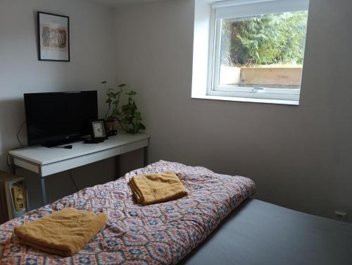 Habitación con cama, escritorio y ventana. en 2 Bedrooms Furnished Semi-basement Apartment - close to everything in Moss en Moss
