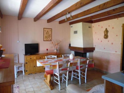 une cuisine avec une table et des chaises dans une pièce dans l'établissement Le Chardonnay - Gîte - Lot (vallée de la Dordogne), à Saint-Michel-de-Bannières