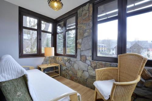 a bedroom with a stone wall and a bed and chairs at Dom Polana Karpacz in Karpacz
