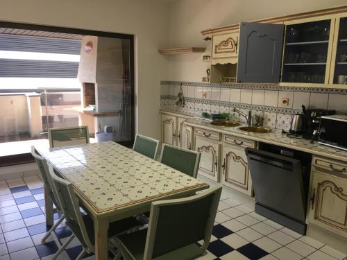 cocina con mesa, sillas, mesa y barra en Le XIII, en Hoenheim