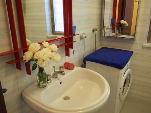 een badkamer met een wastafel en een vaas met bloemen bij Villa Calipso - Appartamento in Villa con giardino e wi-fi in Ovile la Marinella