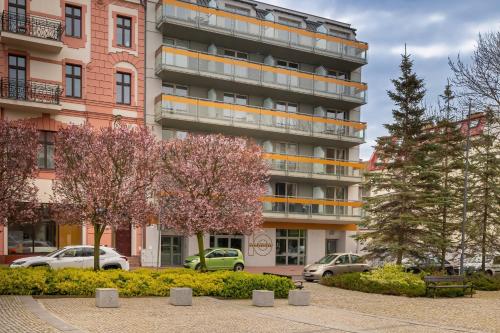 Un edificio de apartamentos con coches aparcados delante. en Modern Studio with Garden in Świnoujście by Noclegi Renters, en Świnoujście