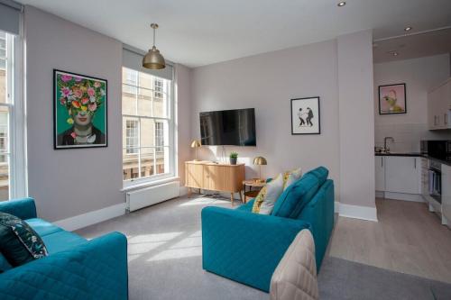 sala de estar con 2 sillas azules y TV en ※ Stunning Apt - Centre of Historic Bath ※, en Bath