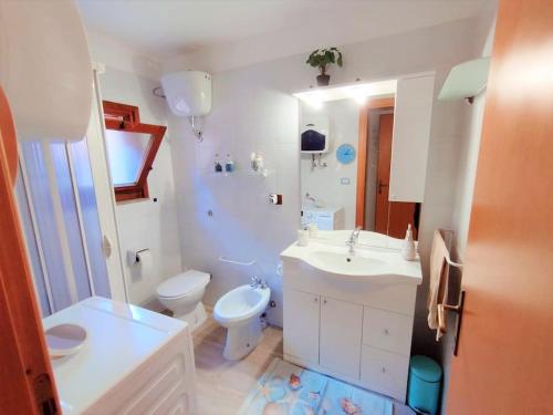 ein weißes Bad mit einem WC und einem Waschbecken in der Unterkunft Grazioso monolocale in Sardegna in Marina di Sorso