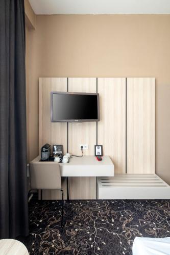 a hotel room with a desk with a flat screen tv at The Alfred Hotel in Amsterdam