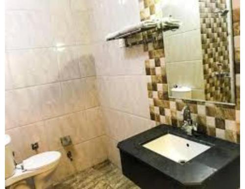 a bathroom with a sink and a toilet at Bharti Hotel Uhdampur in Udhampur
