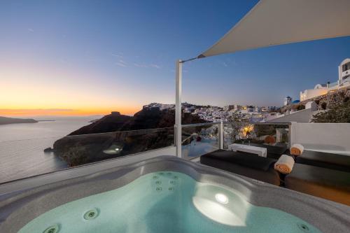 a bath tub in a room with a view of the ocean at Nevma Suites in Firostefani