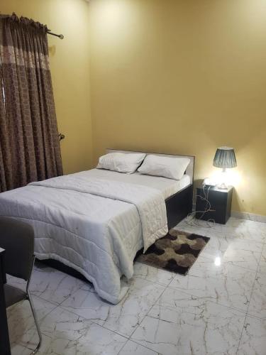 um quarto com uma cama, uma mesa e um candeeiro em Truth Key Hotel & Suites em Lagos