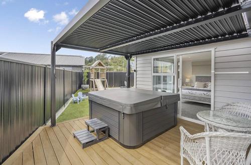 a patio with a barbecue grill on a deck at Private Ensuite with Spa in Upper Hutt in Upper Hutt