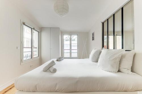 Cette chambre blanche dispose d'un grand lit blanc et de fenêtres. dans l'établissement L'étincelle - Lumineux - Vue Tour Eiffel - BM, à Paris