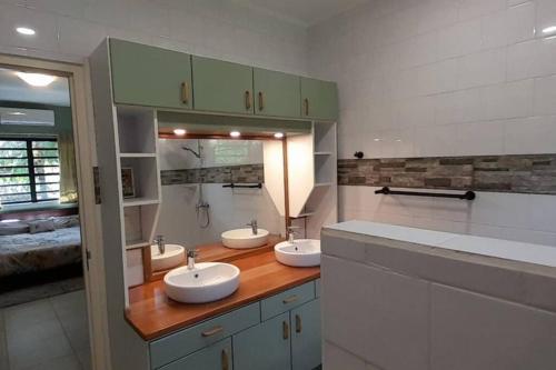 a bathroom with three sinks and a mirror at Comfortabele vakantiewoning in Wanica, Suriname in Wanica