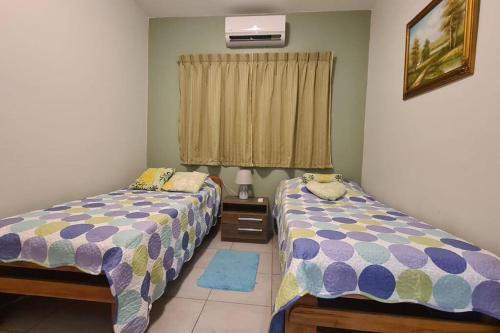 um quarto com 2 camas e uma janela em Comfortabele vakantiewoning in Wanica, Suriname em Wanica