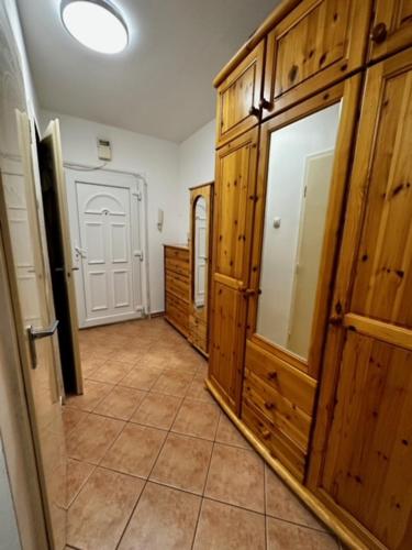 a hallway with wooden doors and a tiled floor at Asgard Apartman in Zalaegerszeg