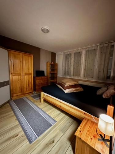 a bedroom with a large bed and wooden floors at Asgard Apartman in Zalaegerszeg