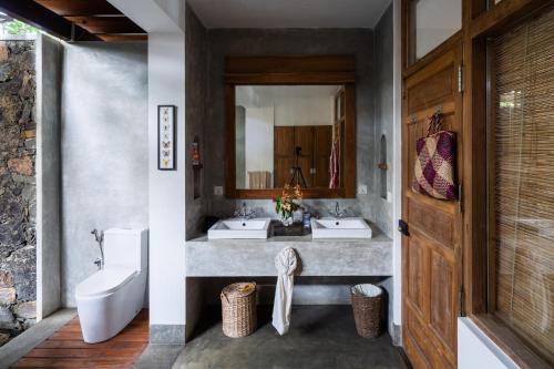 La salle de bains est pourvue de 2 lavabos et d'un miroir. dans l'établissement Royal Indigo Villa, à Talpe