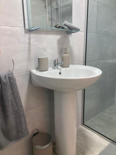 a white bathroom with a sink and a shower at Boutique Townhouses Letterfrack Village - Entrance to Connemara National Park in Galway