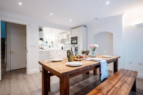 a kitchen with a wooden table and a wooden bench at Luxury 3BRs house in the heart of Victoria in London
