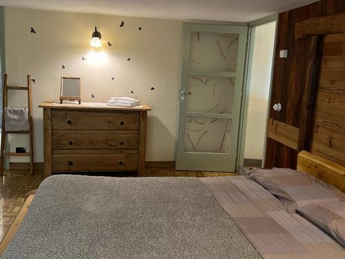 a bedroom with a bed and a dresser and a door at Profumo Di Legno in Aosta