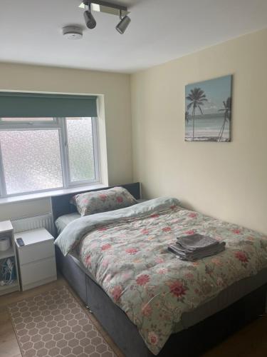 a bedroom with a bed and a window at L-Houses in Dagenham