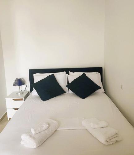 a white bed with two towels on top of it at Royal View in Mani in Kokkala