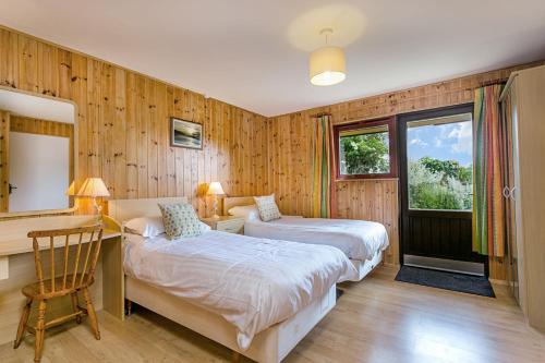 1 Schlafzimmer mit 2 Betten, einem Schreibtisch und einem Tisch in der Unterkunft Laburnum Lodge in Minehead