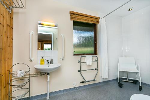 ein weißes Badezimmer mit einem Waschbecken und einem Spiegel in der Unterkunft Laburnum Lodge in Minehead