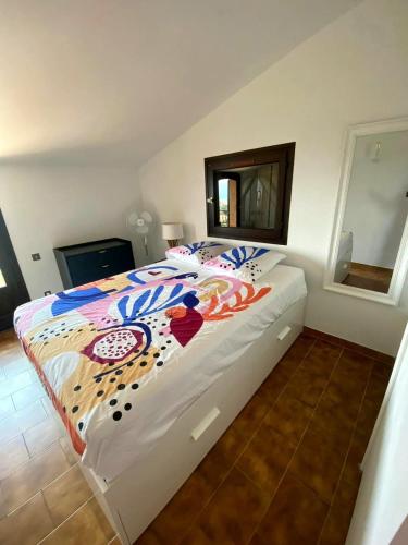 a bedroom with a large bed with a colorful comforter at La Casa San Biaggio in Ajaccio