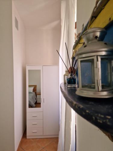 um quarto com uma cama e um espelho em LA CASETTA AZZURRA CHIANALEA - locazione turistica em Scilla