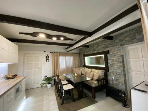 a kitchen and dining room with a table and a brick wall at Къща за гости “Дългая” in Targovishte