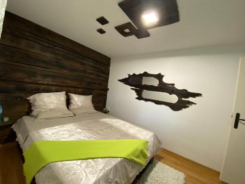 a bedroom with a bed with a wooden headboard at Къща за гости “Дългая” in Targovishte