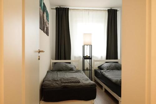 1 dormitorio con 2 camas y ventana en Möblierte 3-Zimmer-Wohnung nahe Düsseldorf in Duisburg-Süd en Duisburg