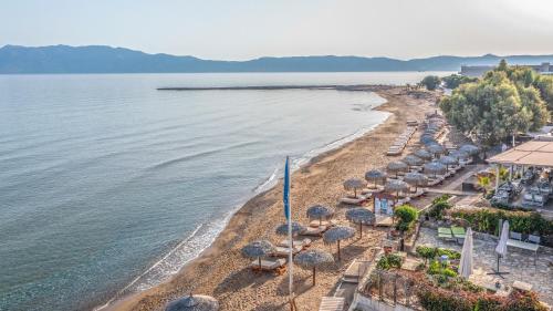 - une vue aérienne sur une plage avec des parasols et l'océan dans l'établissement Maria Beach Hotel, à Kíssamos