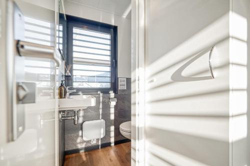 uma casa de banho com um lavatório e um WC em STAY24 - Wasservilla Chalet am Meer em Peenemünde