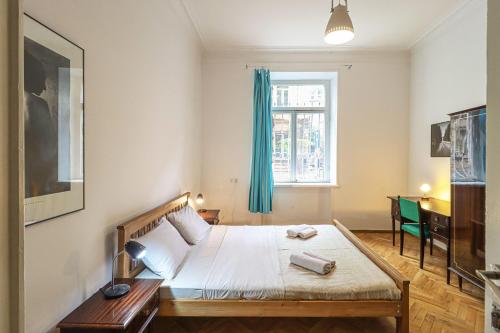 um quarto com uma cama e uma janela em INOLA Sunny flat with balcony in central Tbilisi em Tbilisi