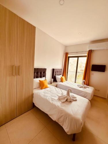 duas camas num quarto de hotel com toalhas em Dome Luju em Mosta
