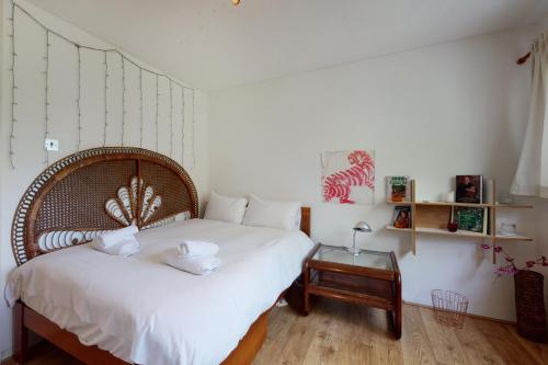 um quarto com uma cama com lençóis brancos e uma mesa em 3bed house with patio & parking - 9 min to Station em Londres