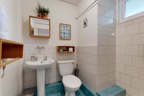 a bathroom with a toilet and a sink at 3bed house with patio & parking - 9 min to Station in London