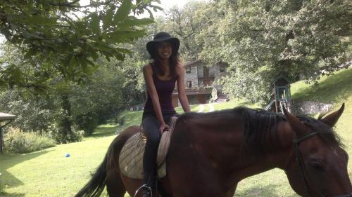 a young woman riding on the back of a horse at agriturismo il riccio in Cedegolo