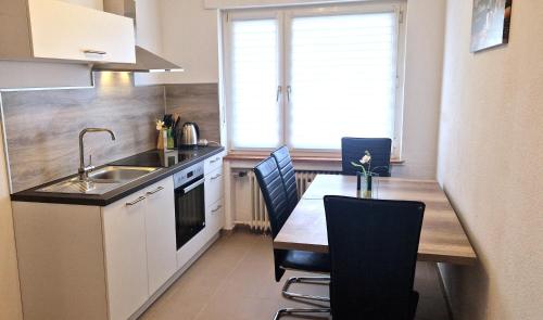 eine Küche mit einem Waschbecken und einem Tisch mit Stühlen in der Unterkunft Apartment Sson in Paderborn