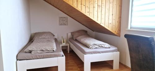 two beds in a room under a stair case at Apartment Sson in Paderborn