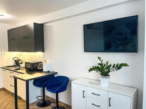 a kitchen with a desk and two blue chairs in a room at Apartament nad Zalewem in Serock