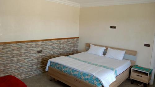 a bedroom with a bed and a brick wall at Ferme de Rayan in Safi